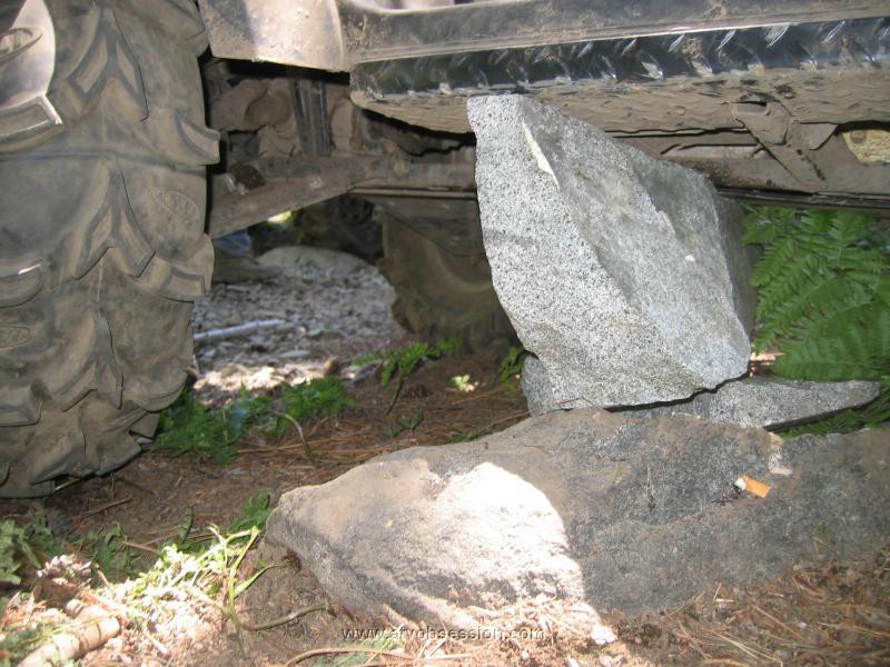 12. Dan uses a rock under his skid plate to jack the tire up..jpg